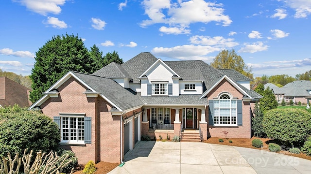 1404 Churchill Downs Dr, Waxhaw, NC 28173 - traditional-style house featuring covered porch, driveway, a garage, brick siding, and a shingled roof
