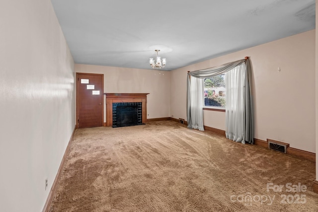 unfurnished living room with baseboards, a chandelier, carpet floors, visible vents, and a tile fireplace