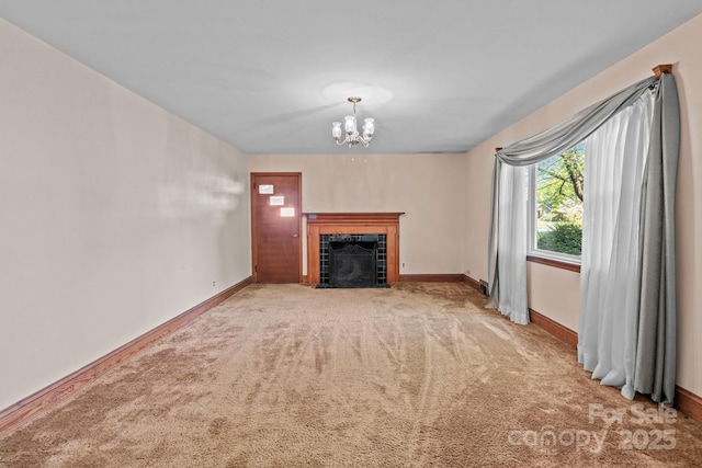 unfurnished living room featuring carpet floors, baseboards, a notable chandelier, and a fireplace