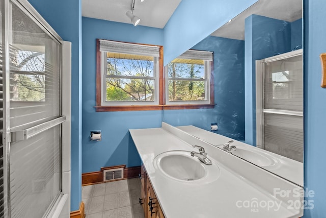 bathroom featuring visible vents, baseboards, rail lighting, and vanity