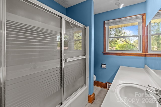 bathroom featuring tile patterned flooring, visible vents, toilet, a sink, and baseboards