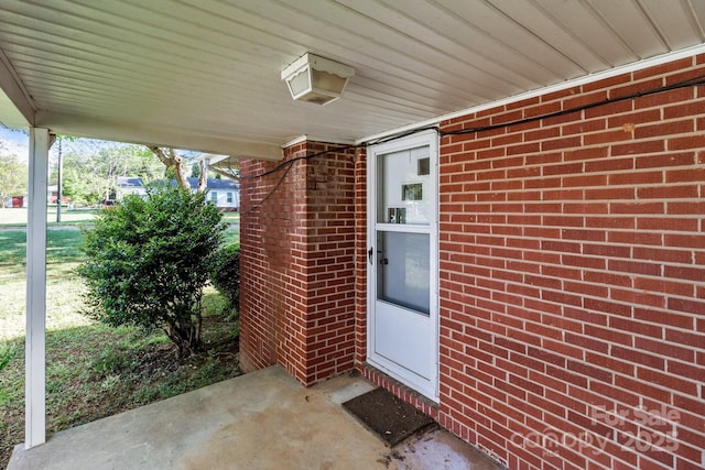 doorway to property with brick siding