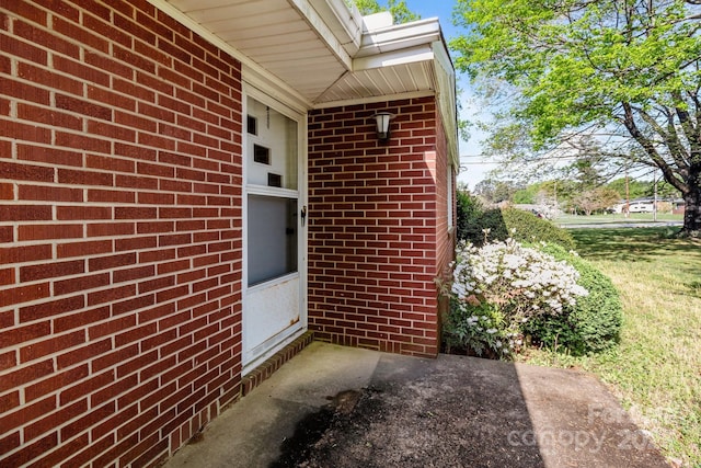 view of exterior entry featuring brick siding
