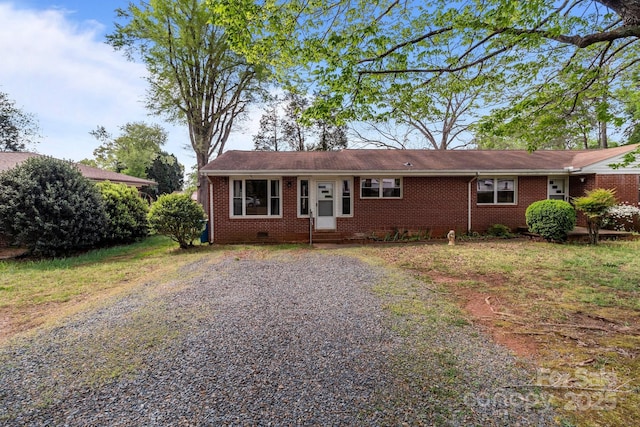 ranch-style house featuring crawl space, entry steps, driveway, and brick siding