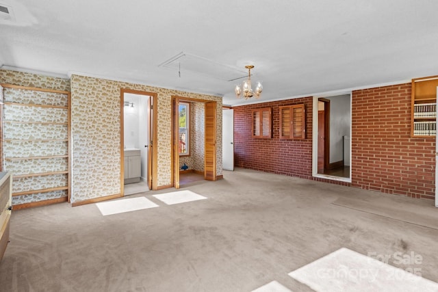 interior space with an inviting chandelier, brick wall, visible vents, and attic access