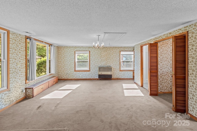 unfurnished living room with a textured ceiling and wallpapered walls