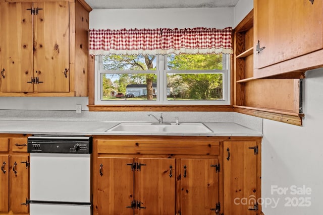 kitchen with a wealth of natural light, white dishwasher, light countertops, and a sink