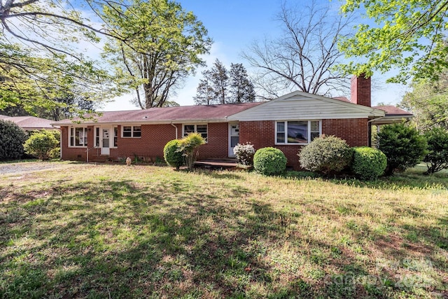 ranch-style home featuring brick siding, a chimney, and a front lawn