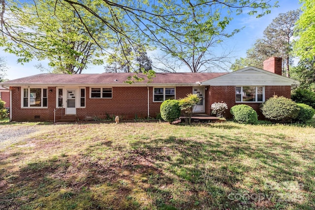 ranch-style house featuring entry steps, crawl space, a chimney, brick siding, and a front lawn