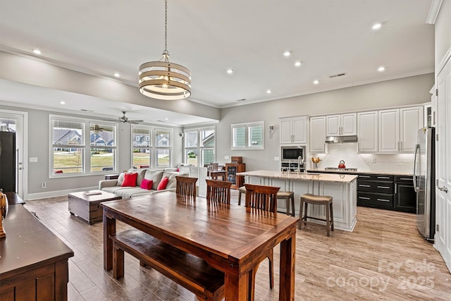 8718 Festival Way, Charlotte, NC 28215 - dining space with ornamental molding, recessed lighting, light wood-style flooring, visible vents, and ceiling fan with notable chandelier