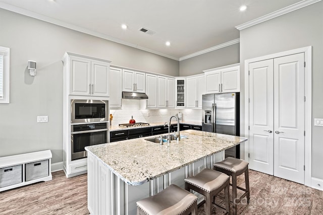 8718 Festival Way, Charlotte, NC 28215 - kitchen with white cabinets, under cabinet range hood, visible vents, stainless steel appliances, and a sink
