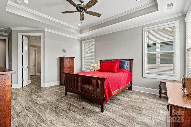 8718 Festival Way, Charlotte, NC 28215 - bedroom with ornamental molding, a tray ceiling, baseboards, and wood finished floors