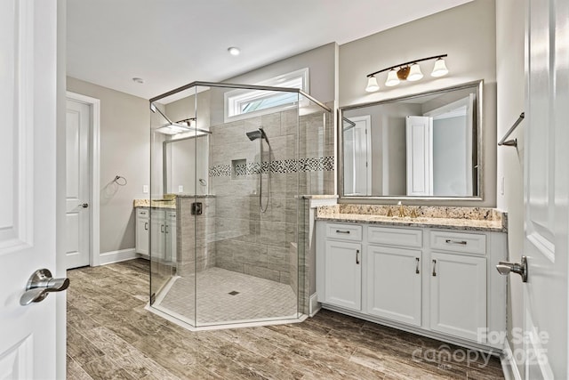 8718 Festival Way, Charlotte, NC 28215 - bathroom with vanity, baseboards, a stall shower, and wood finished floors