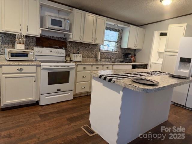 5061 Windy Woods Rd, Morganton, NC 28655 - kitchen with a sink, white cabinetry, dark wood finished floors, white appliances, and visible vents
