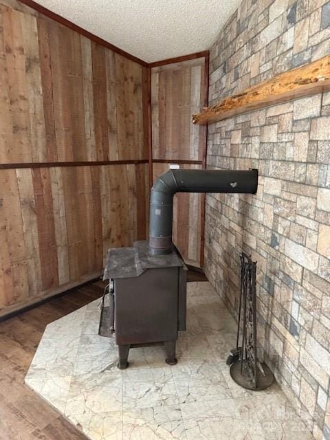 5061 Windy Woods Rd, Morganton, NC 28655 - details featuring a textured ceiling, wood finished floors, a wood stove, and wood walls