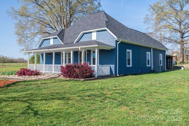 view of front of house featuring a front yard, a shingled roof, and covered porch