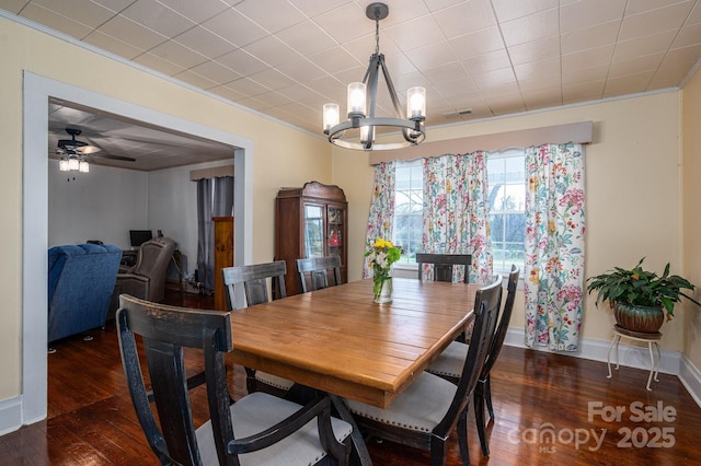 dining space featuring visible vents, baseboards, crown molding, wood finished floors, and ceiling fan with notable chandelier