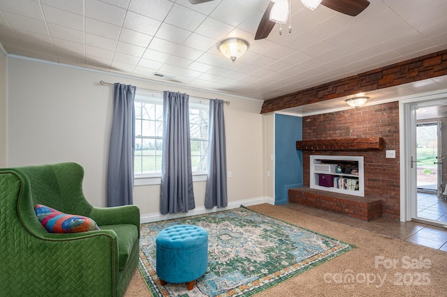 tiled living room with a healthy amount of sunlight, ceiling fan, a fireplace, and visible vents