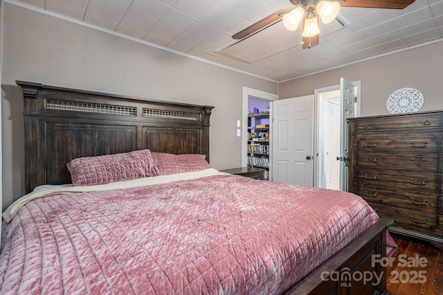 bedroom with wood finished floors, ceiling fan, and ornamental molding