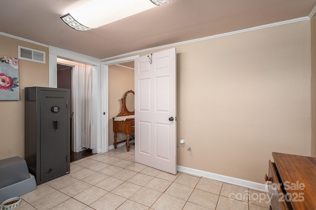 interior space featuring crown molding, visible vents, baseboards, and light tile patterned flooring