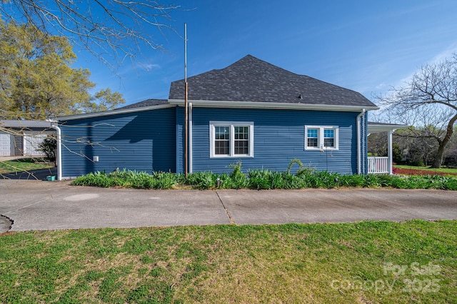 view of property exterior with a yard and a shingled roof