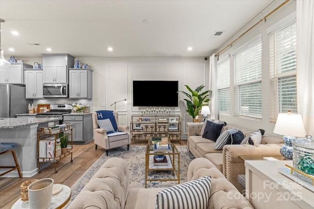 1354 Galloway Rd, Charlotte, NC 28262 - living room featuring light wood-type flooring, a decorative wall, visible vents, and recessed lighting