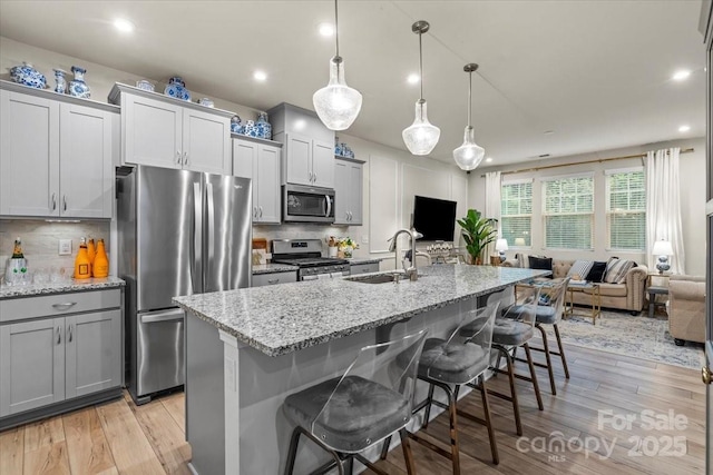 1354 Galloway Rd, Charlotte, NC 28262 - kitchen featuring open floor plan, light wood-style floors, a sink, and stainless steel appliances