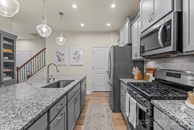 1354 Galloway Rd, Charlotte, NC 28262 - kitchen with light wood-style flooring, a sink, stainless steel appliances, gray cabinetry, and backsplash
