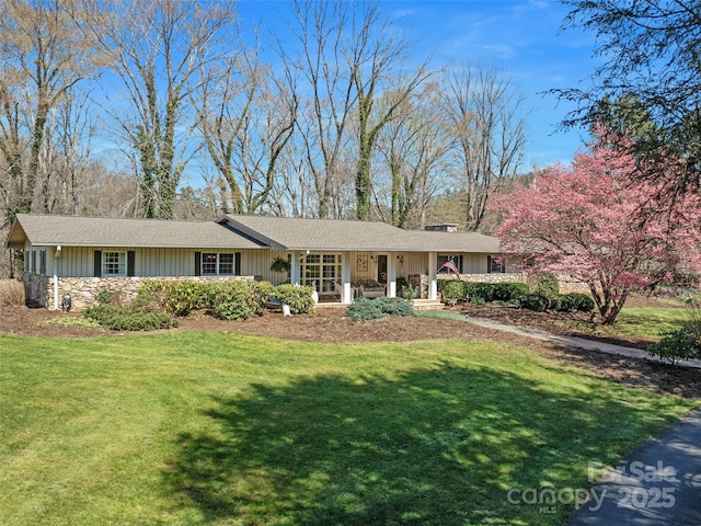 ranch-style home featuring a porch, board and batten siding, and a front lawn