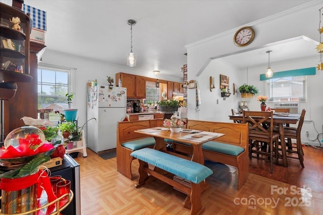 dining room with healthy amount of natural light and crown molding