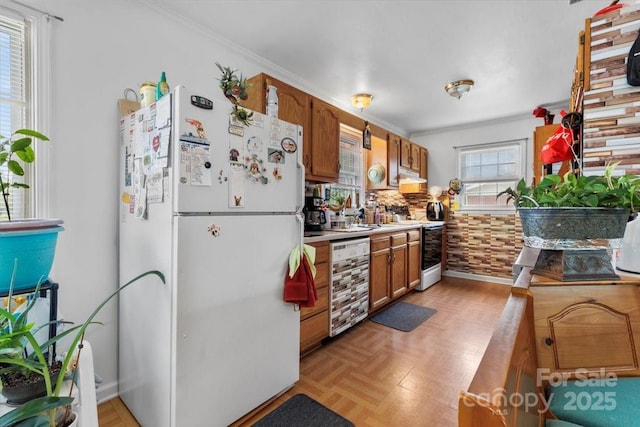 kitchen featuring white appliances, brown cabinets, under cabinet range hood, wine cooler, and light countertops