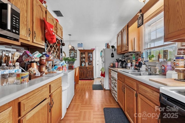 kitchen with stainless steel microwave, a sink, light countertops, and electric stove