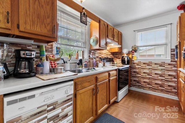 kitchen featuring range with electric stovetop, dishwashing machine, under cabinet range hood, light countertops, and brown cabinets