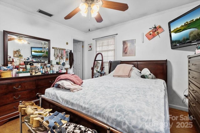 bedroom with wood finished floors, ornamental molding, a ceiling fan, and baseboards