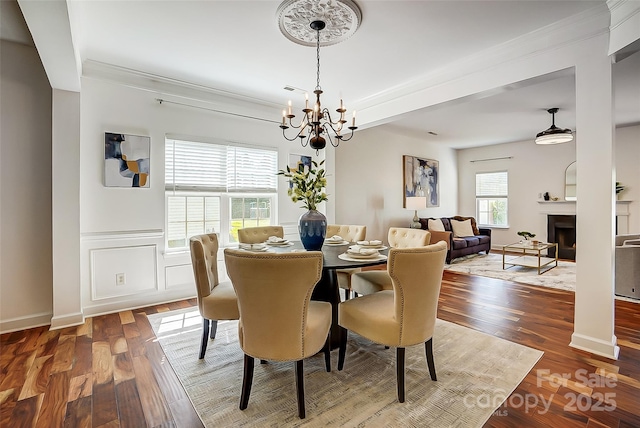 5713 Falkirk Ln, Matthews, NC 28104 - dining room with a chandelier, wood finished floors, ornamental molding, and a fireplace