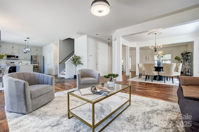 5713 Falkirk Ln, Matthews, NC 28104 - living room featuring a chandelier, stairway, and wood finished floors