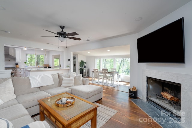 living area with ceiling fan, recessed lighting, plenty of natural light, and wood finished floors