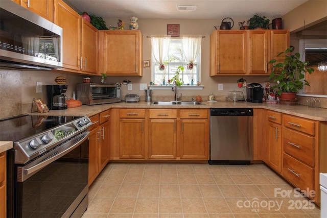 5127 Fernhill Dr, Charlotte, NC 28217 - kitchen with light countertops, light tile patterned flooring, visible vents, stainless steel appliances, and a sink