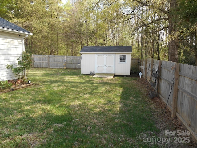 view of yard with a shed, a fenced backyard, and an outdoor structure