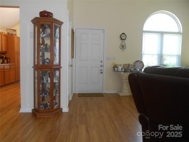 foyer with baseboards and light wood-style floors