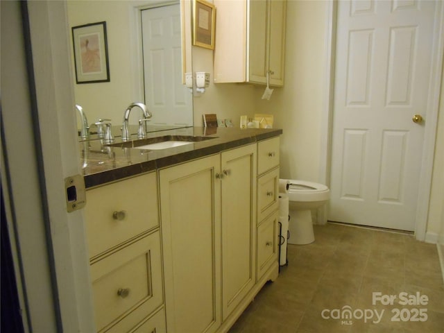 bathroom featuring toilet, vanity, and tile patterned flooring