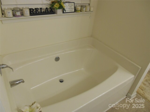 bathroom with tile patterned floors and a bath