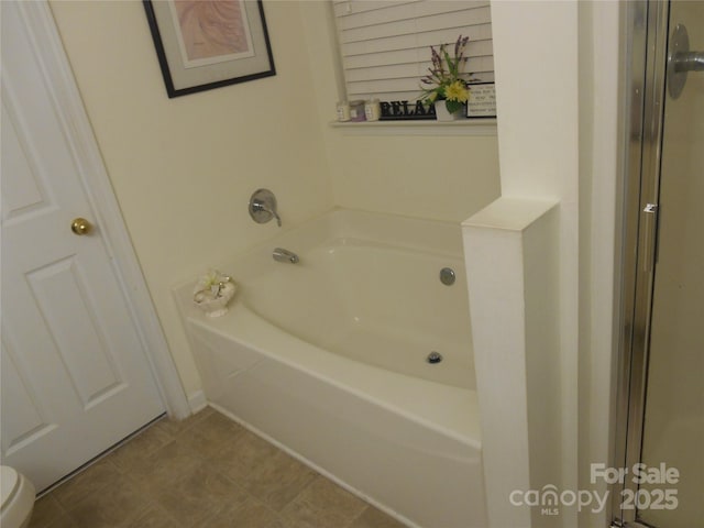 full bathroom featuring toilet and a bath