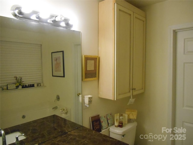 bathroom featuring a tub to relax in and toilet