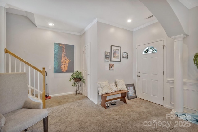 carpeted foyer with baseboards, arched walkways, ornamental molding, decorative columns, and stairway