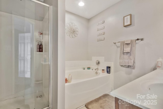 bathroom with vanity, a bath, and a stall shower