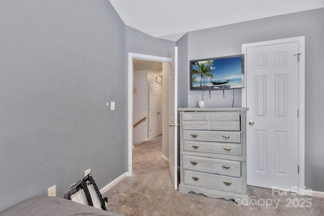 bedroom with light colored carpet and baseboards