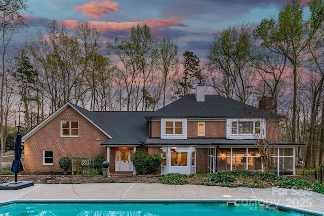 5750 Hemby Rd, Matthews, NC 28104 - back of property with brick siding, a chimney, an outdoor pool, and a sunroom