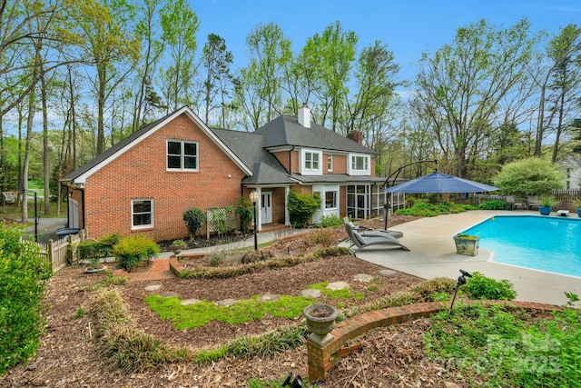 5750 Hemby Rd, Matthews, NC 28104 - rear view of property featuring a chimney, brick siding, fence, a fenced in pool, and a patio