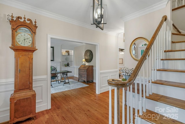 5750 Hemby Rd, Matthews, NC 28104 - foyer entrance with crown molding, light wood finished floors, a wainscoted wall, and stairway